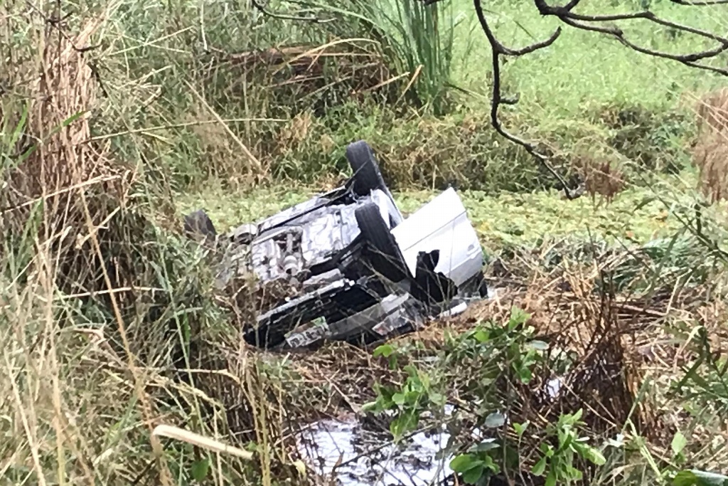 Auto compacto se sale de carretera y queda volcado en Veracruz